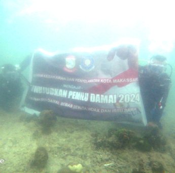 Damkar Makassar Bentangkan Bendera Pemilu Damai di Kedalaman 12 Meter Pulau Samalona