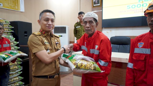 Camat Ujung Tanah Amanda Syahwaldi menyalurkan bantuan beras kepada petugas kebersihan hasil potongan zakat ASN se-Kota Makassar, di Aula Kantor Kecamatan Ujung Tanah, Selasa (19/3) || istimewa 