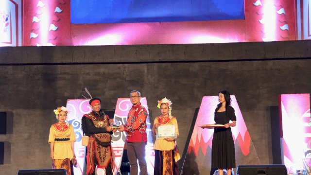 Dirjen IKP Kementrian Kominfo Usman Kansong memberikan penghargaan kepada salah satu KIM terbaik pada malam apresiasi KIM Fest 2024 di Anjungan City Of Makassar, Sabtu (10/8) || istimewa 